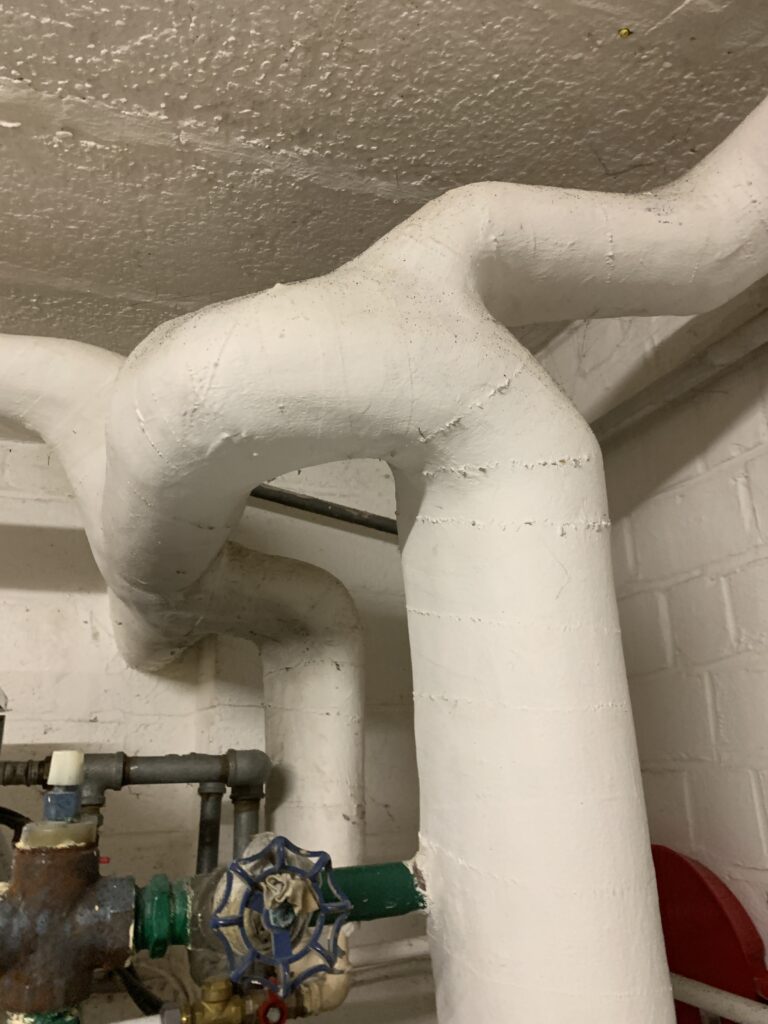 Asbesthoudende leidingisolatie in een kelder